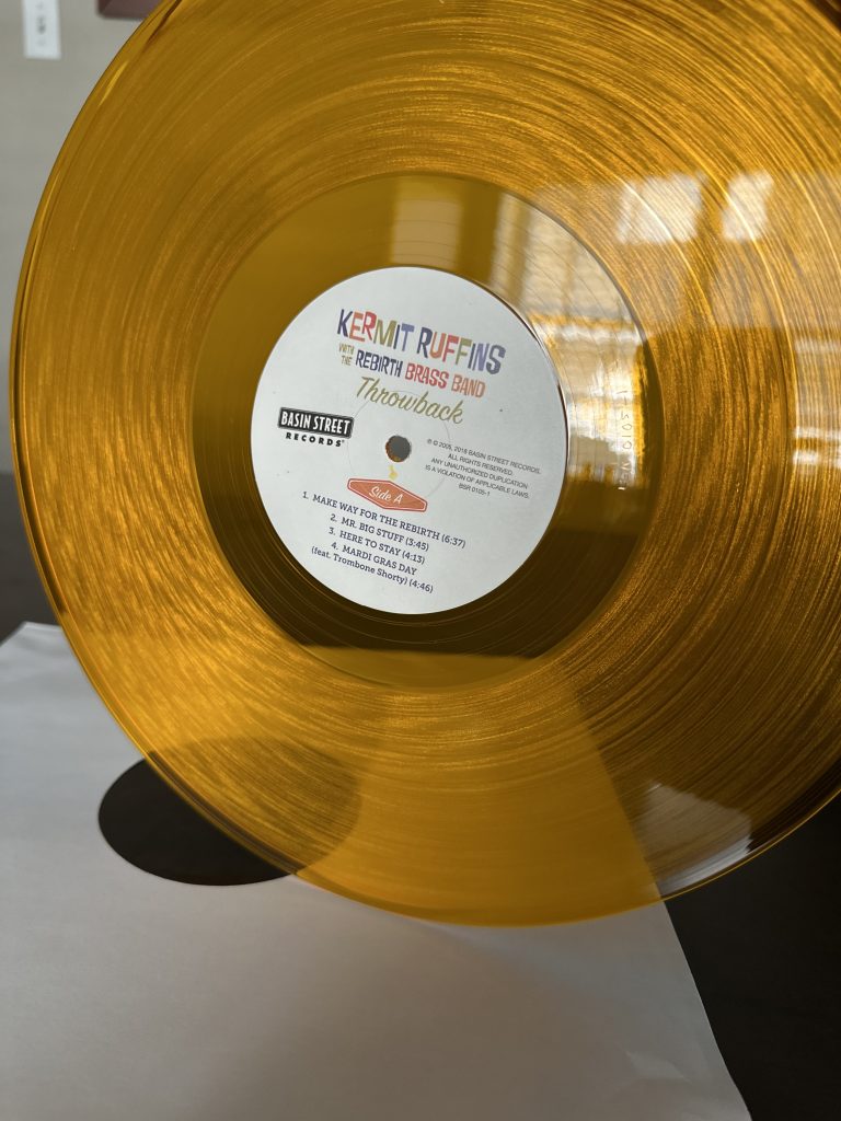 An image of the translucent orange vinyl of the album Throwback by Kermit Ruffins with Rebirth Brass Band